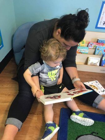2-year-old_boy_and_teacher_reading_book_at_cadence_academy_preschool_north_attleborough_ma-338x450