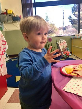 2-year-old_boy_enjoying_apple_juice_at_superman_preschooler_cadence_academy_preschool_rocklin_ca-338x450