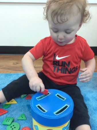 2-year-old_doing_button_sorting_activity_at_cadence_academy_preschool_west_bridgewater_ma-338x450