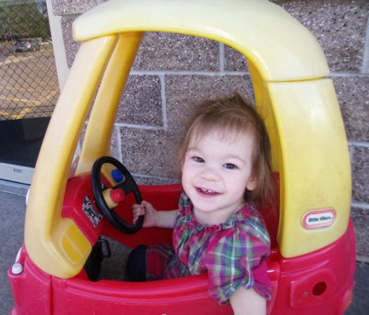 2-year-old_girl_in_little_tikes_car_cadence_academy_preschool_centennial_co-527x450