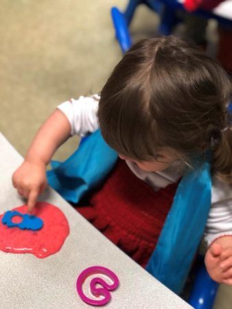 2-year-old_girl_making_shapes_with_slime_cadence_academy_preschool_sellwood_portland_or-338x450