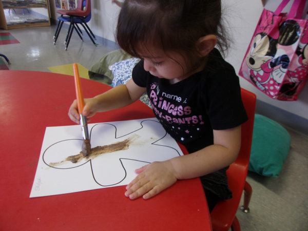 2-year-old_girl_painting_gingerbread_man_cadence_academy_preschool_smoky_hill_aurora_co-600x450