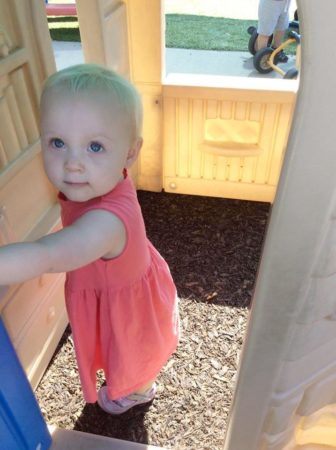 2-year-old_girl_playing_in_house_on_playground_cadence_academy_preschool_johnston_ia-336x450