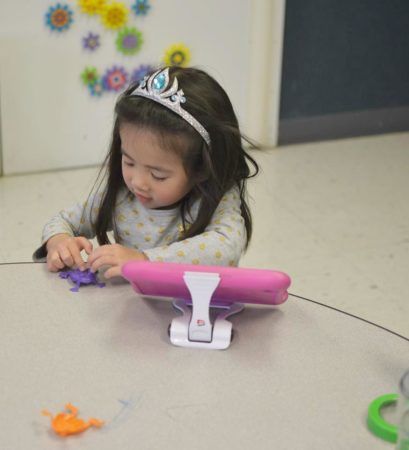 2-year-old_girl_playing_with_plastic_frog_winwood_childrens_center_fairfax_va-409x450