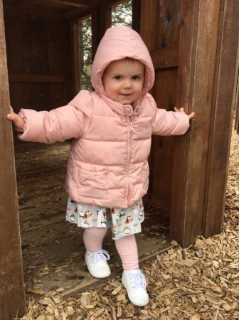 2-year-old_girl_stepping_out_of_wooden_house_on_playground_cadence_academy_preschool_tualatin_or-336x450