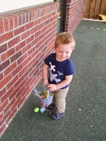 2-year-old_hunting_for_easter_eggs_cadence_academy_northlake_charlotte_nc-338x450