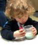 2-year-old_looking_at_goop_in_cup_cadence_academy_preschool_sellwood_portland_or-381x450