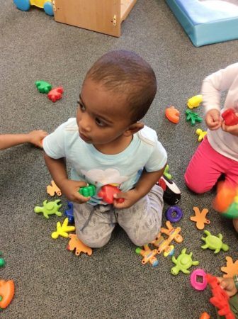 2-year-old_playing_with_gingerbread_mean_and_turtles_cadence_academy_preschool_greensboro_nc-336x450