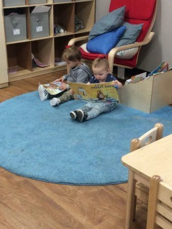 2-year-olds_reading_books_on_rug_at_cadence_academy_preschool_west_bridgewater_ma-338x450