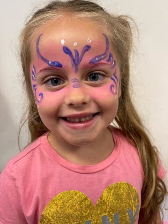 A child with facepaint indoors