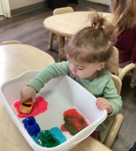 child playing with toy cars and playdough at cadence academy preschool and daycare in dupont washington