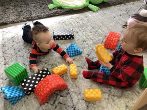 infants playing together with blocks on the floor at cadence academy preschool and daycare in dupont washington