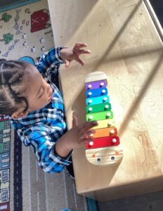 young boy playing with musical instrument at desk at cadence academy preschool and daycare in dupont washington