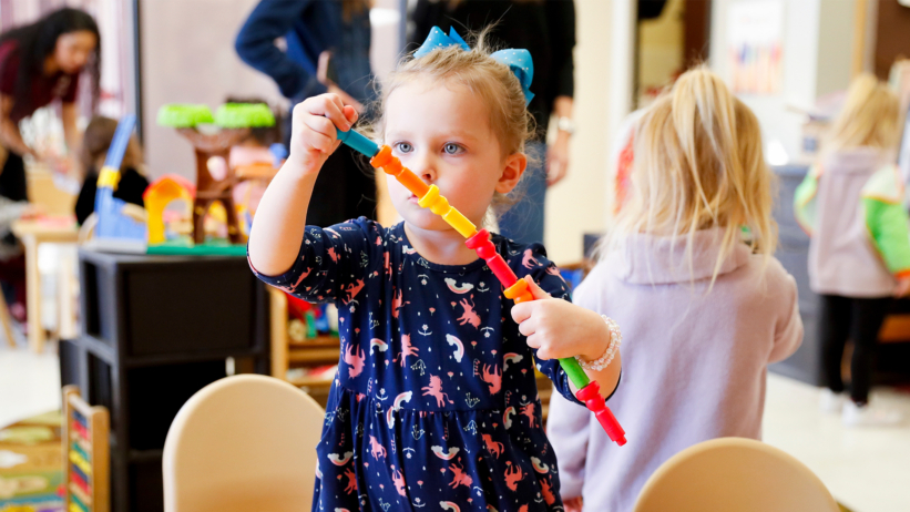 Child playing with building toy during hands-on learning activity at Craycroft