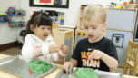 two preschool students engaged in a hands on classroom learning activity with sensory materials at Craycroft