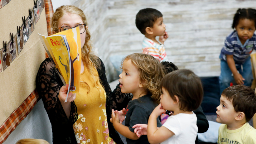 teacher leading children during a group learning activity at Craycroft