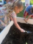 Child using shovel to plant seeds in dirt at crestwood