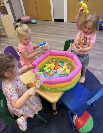Children playing with toys in inflatable pool bin at crestwood