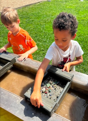 Children panning for rocks in water at crestwood