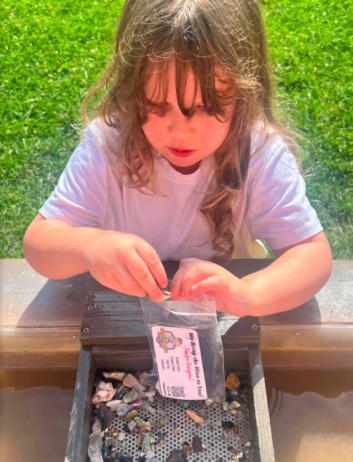 child panning for special rocks in water at crestwood