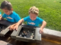 child panning for special rocks in water at crestwood
