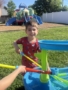 child playing with water outside at crestwood