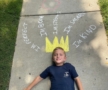 child posing with chalk art crown on sidewalk at preschool and daycare cadence academy preschool 502 spring hill