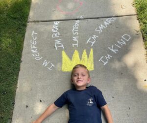 child posing with chalk art crown on sidewalk at preschool and daycare cadence academy preschool 502 spring hill