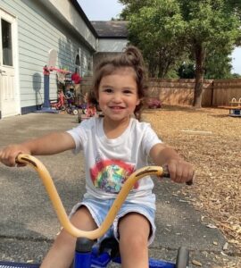 young girl riding bicycle on playground at cadence academy preschool and daycare in dupont washington