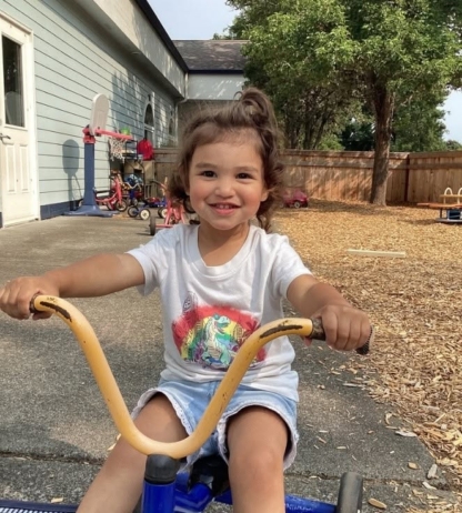 young girl riding bicycle on playground at cadence academy preschool and daycare in dupont washington