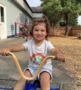 young girl riding bicycle on playground at cadence academy preschool and daycare in dupont washington