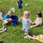 Children sitting in grass outside at Creative Kids Childcare Centers Beekman