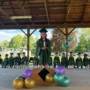 Child standing on stage with classmates behind her at graduation at Creative Kids Childcare Centers Beekman