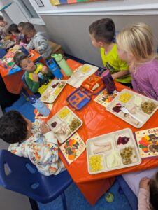 Children eating thanksgiving food together at Creative Kids Childcare Centers Beekman