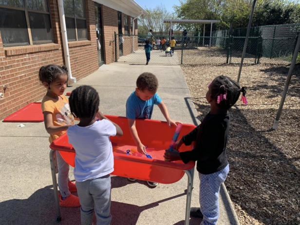 Children playing outside in toy bin at cadence academy preschool and daycare northeast