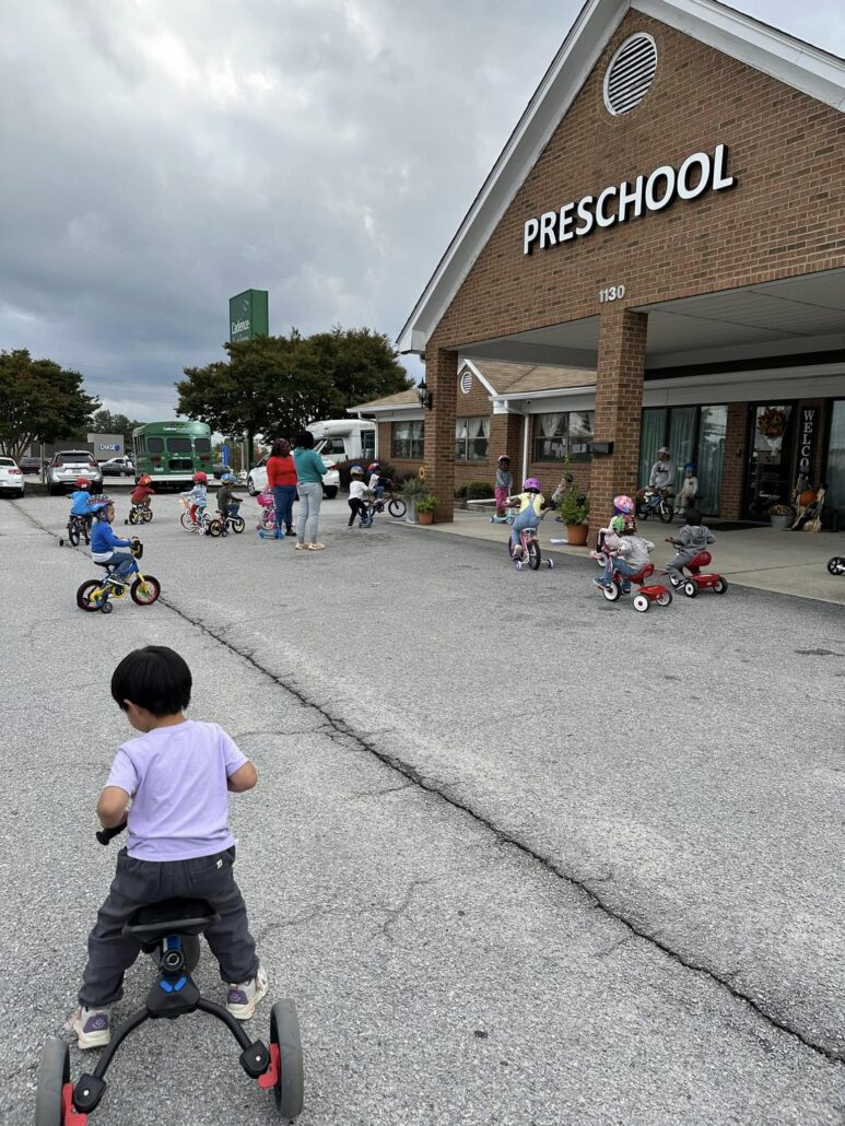 children riding bikes outside of cadence academy preschool and daycare northeast