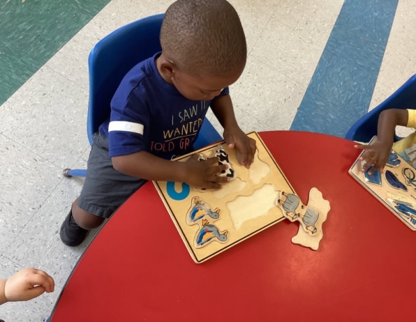 child matching shapes inside classroom at cadence academy preschool and daycare northeast