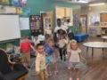 children and teacher hula hooping in classroom at cadence academy preschool and daycare northeast