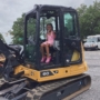 child sitting in excavator during touch-a-truck day at cadence academy preschool and daycare mauldin