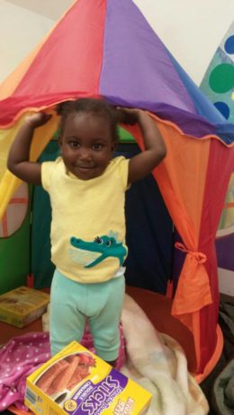 A child playing in a fort indoors