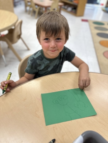 male child smiling with drawing made at cadence academy chandler heights