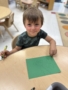 male child smiling with drawing made at cadence academy chandler heights