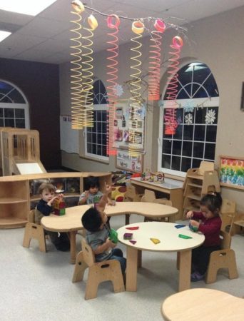 boy_pointing_at_slinky_chandelier_cadence_academy_preschool_dupont_wa-342x450