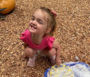 young girl playing outside with bubbles at cadence academy preschool and daycare in dupont washington