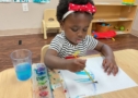 Child doing art painting inside at Cadence Academy Preschool Olive Branch, Mississippi