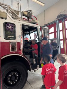 child getting into firetruck at preschool and daycare at cadence academy preschool in the colony texas