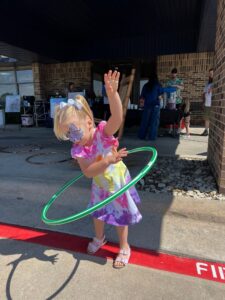 child hoola hooping outside at preschool and daycare at cadence academy preschool in the colony texas