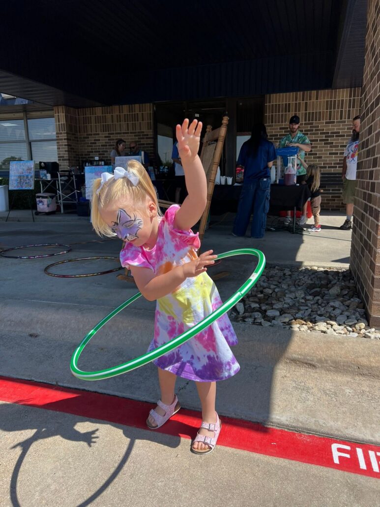 child hoola hooping outside at preschool and daycare at cadence academy preschool in the colony texas