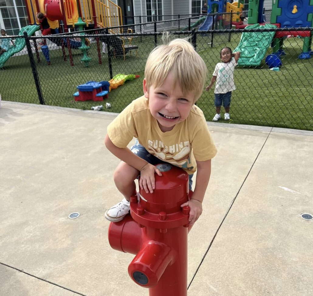 Child smiling climbing outside at Cadence academy preschool and daycare 505 murfreesboro