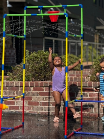 child playing in water outside
